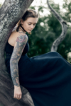 Portrait - Femme au bras tatouée sur un arbre