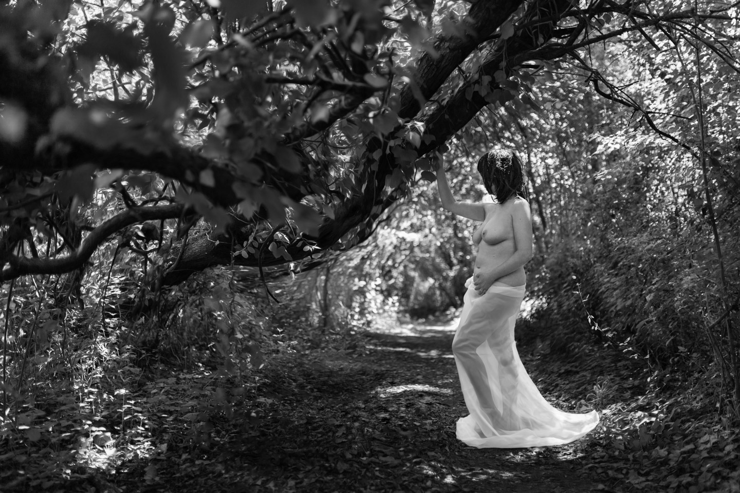 Portrait noir et blanc d'une femme nue en forêt