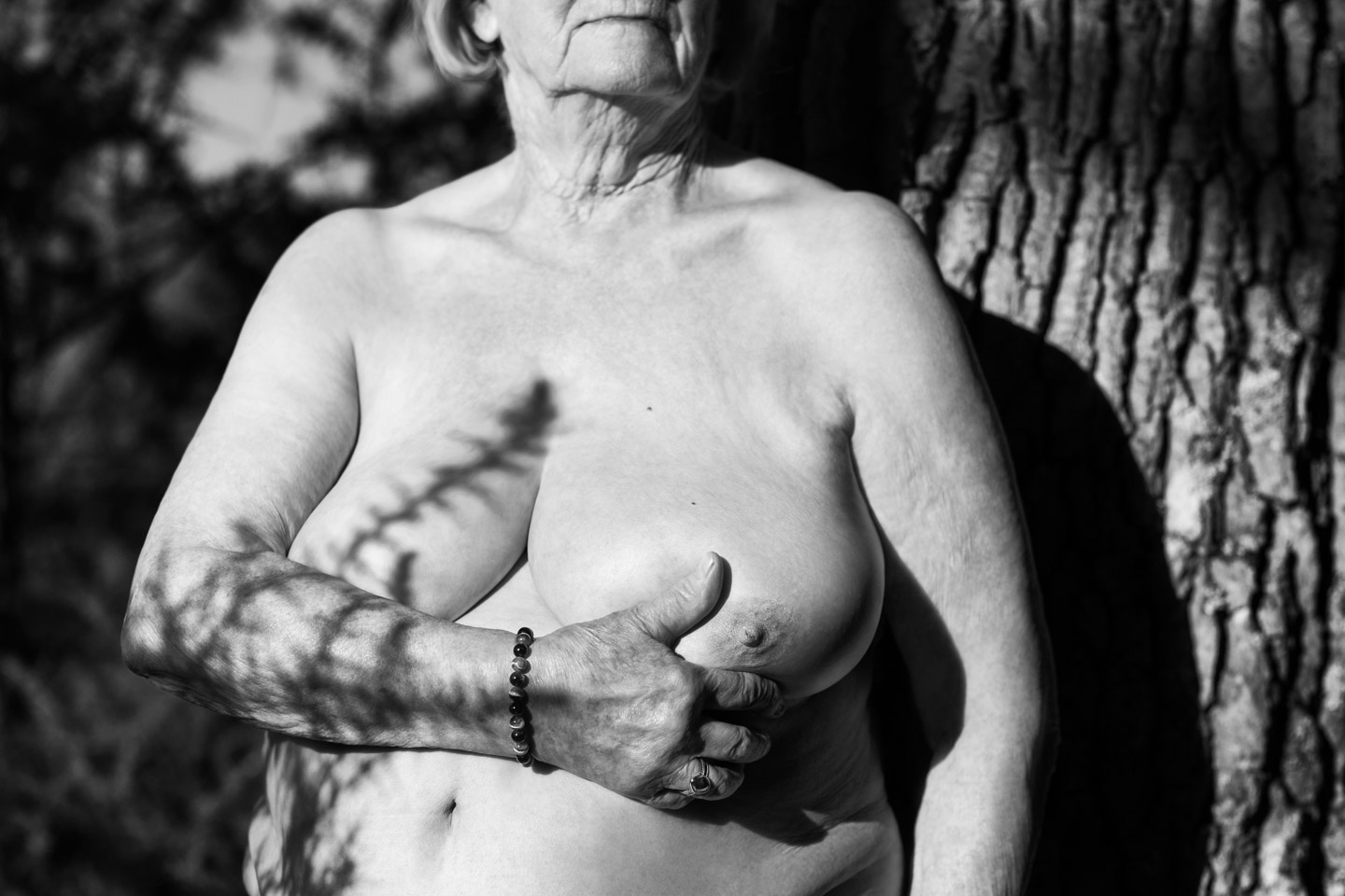 Portrait noir et blanc d'une femme nue en forêt